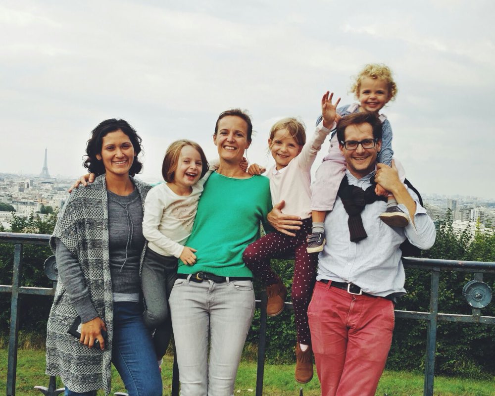 Au pair mexicana con su familia anfitriona en un mirador de París, con la Torre Eiffel al fondo